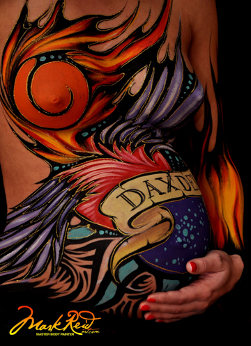 woman in body paint with a painting that seems to reveal part of the name of the baby, Daxton
